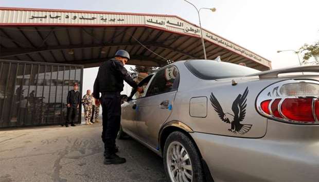 A Jordanian policeman checks a car at Jordan's Jaber border crossing checkpoint near Syria's Nasib checkpoint, near Mafraq