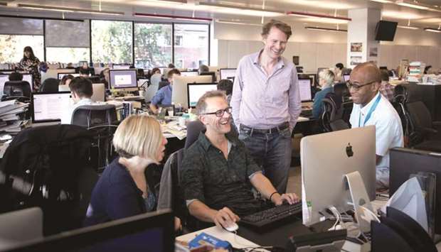 Journalist Luke Harding (centre standing) speaking with colleagues in the Guardian office.