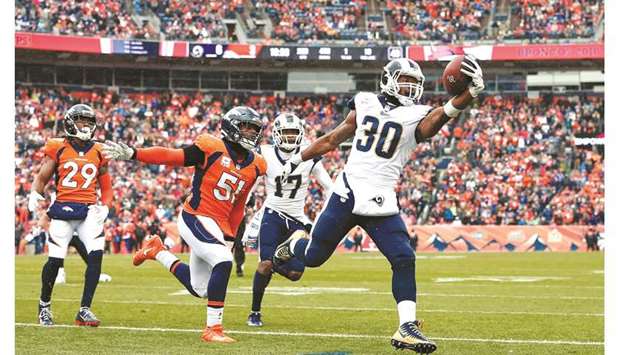 Los Angeles Ramsu2019 Todd Gurley II (right) runs for a touchdown ahead of Denver Broncosu2019 Todd Davis (second from left) in the NFL game at the Mile High Stadium in Denver, Colorado, on Sunday. (USA TODAY Sports)