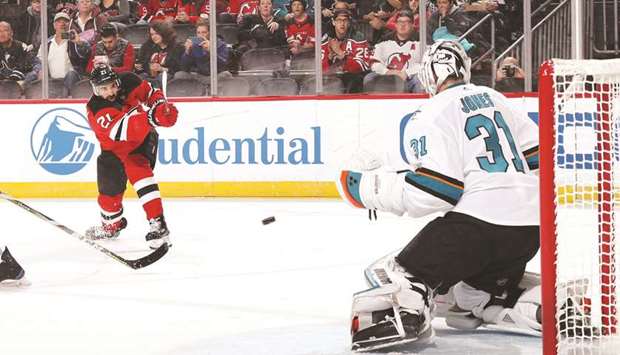 Kyle Palmieri (left) of the New Jersey Devils scores a powerplay goal against Martin Jones of the San Jose Sharks in Newark, New Jersey, on Sunday. (AFP)