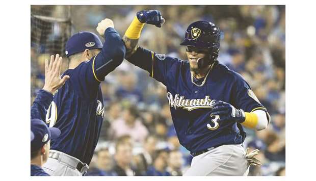 Milwaukee Brewers shortstop Orlando Arcia (right) celebrates in the dugout after hitting a two-run home run against the Los Angeles Dodgers in game three of the 2018 NLCS playoff baseball series in Los Angeles on Monday. (USA TODAY Sports)