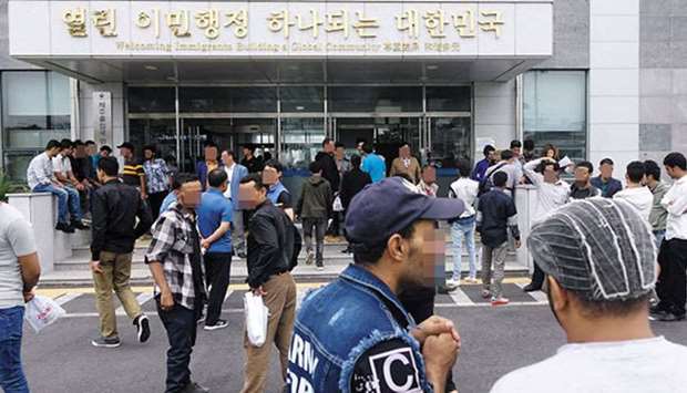 Yemeni asylum seekers wait in front of an immigration office on Jeju Island