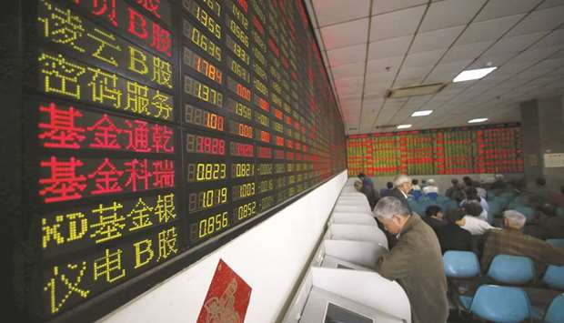 Investors look at computer screens showing stock information at a brokerage house in Shanghai. The Composite index closed down 0.8% to 2,546.33 points yesterday.