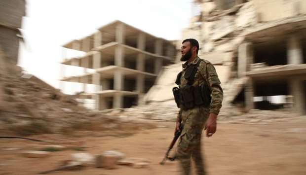 A Syrian rebel-fighter from the National Liberation Front (NLF) walks in a street in the rebel-held al-Rashidin district of western Aleppo's countryside near Idlib province Monday.