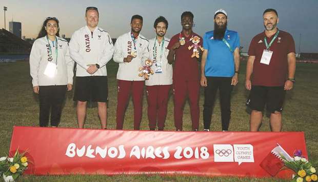 Qataru2019s athletes Abdelaziz Mohamed (third from right) and Owaab Barrow (third from left) pose with the Qatar delegation after winning gold medals at the Youth Olympic Games in Buenos Aires on Tuesday.
