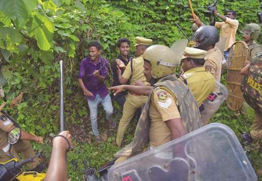Police wield their batons against demonstrators during a protest against the lifting of ban by Supreme Court that allowed entry of women to the Sabarimala temple, at the Nilakkal base camp in Pathanamthitta district in Kerala, yesterday.