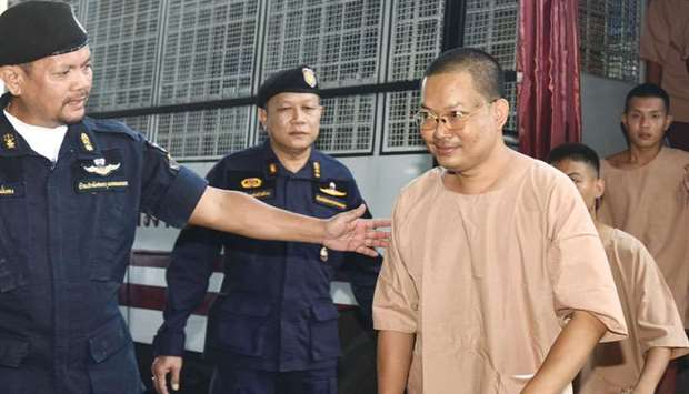 Disgraced monk Wiraphon Sukphon, third left, arrives with other prisoners at a criminal court in Bangkok to face another sentence yesterday.