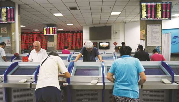 Investors look at computer screens showing stock information at a brokerage house in Shanghai. Chinau2019s efforts to arrest destabilising declines in domestic stocks in recent years have become so well recognised that market players coined the term u201cthe national teamu201d to describe buying by state-owned funds.