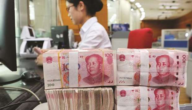 An employee counts 100-yuan notes at a bank in Nantong in Jiangsu province. Chinau2019s total new bank loans in the first nine months of the year jumped 17.7% from a year earlier to 13.14tn yuan, and are on track to make a record year.