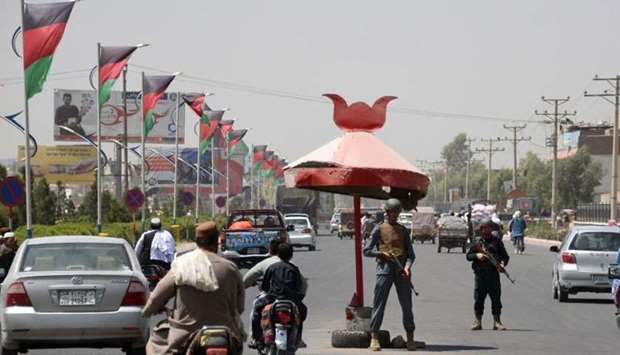 Afghan policemen stand guard at a checkpoint in Kandahar