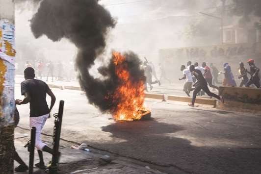 Protesters set fire to block streets as they demonstrate in Port-au-Prince on Wednesday, calling for the resignation of President Jovenel Moise.