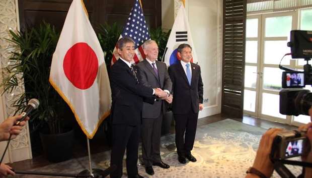 Japan's Defence Minister Takeshi Iwaya (L), US Defence Secretary Jim Mattis (C), and South Korea's Defence Minister Jeong Kyeong-doo, join hands during a photo session before a tri-lateral meeting on the sideline of the Association of Southeast Asian Nations (ASEAN) security summit in Singapore.