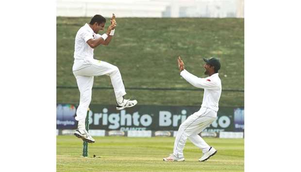 Pakistanu2019s bowler Mohamed Abbas (left) celebrates with teammate after dismissing Australian batsman Travis Head during day four of the second Test in Abu Dhabi yesterday. (AFP)
