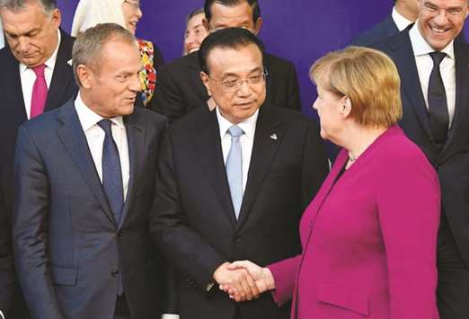 Chinese Premier Li Keqiang and German Chancellor Angela Merkel shake hands at the ASEM leaders summit in Brussels yesterday. At the biennial Asia-Europe meeting bringing together leaders representing 65% of global economic output, France, Britain, Germany, Italy and the European Commission held private meetings with Li, hoping for greater access for EU companies to the worldu2019s No 2 economy.