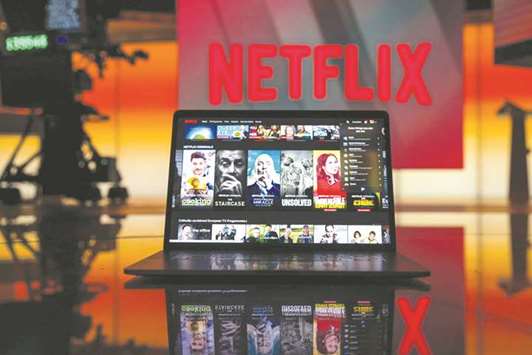 A laptop computer screen displaying the Netflix homepage is seen against an illuminated screen bearing the company logo in London. Netflix claims almost half of US households as customers. Only a small number of other paid streaming services, like HBO Now, have gained more than 5mn subscribers.