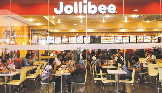 File photo shows customers eat at a Jollibee fast-food outlet in  Quezon City, Metro Manila.