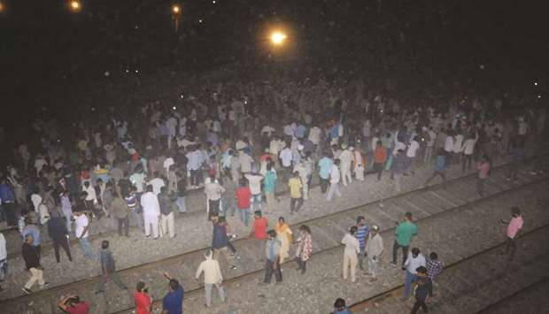 People gather at the site where 50 people were mowed down by a speeding train in Amritsar yesterday.