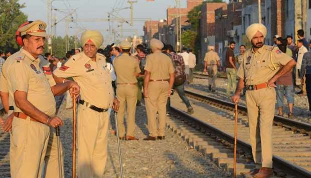 Indian Punjab Police personnel stand guard at the scene of an accident along railroad tracks in Amritsar on October 20, 2018, after revellers who gathered on the tracks were killed by a moving train yesterday.