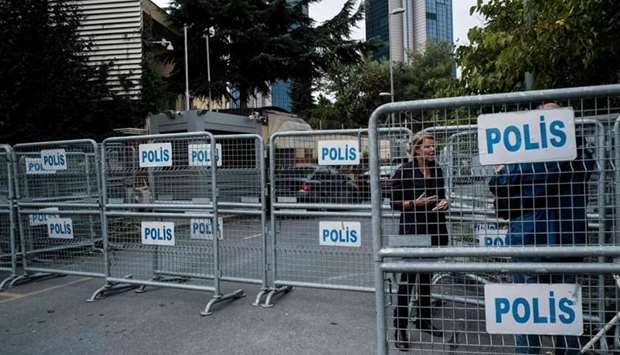 A journalist stands next to police barriers, in front of the Saudi consulate in Istanbul.