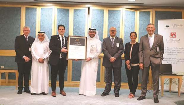 Al Ahli Hospital officials receiving the award for achieving international healthcare re-accreditation.