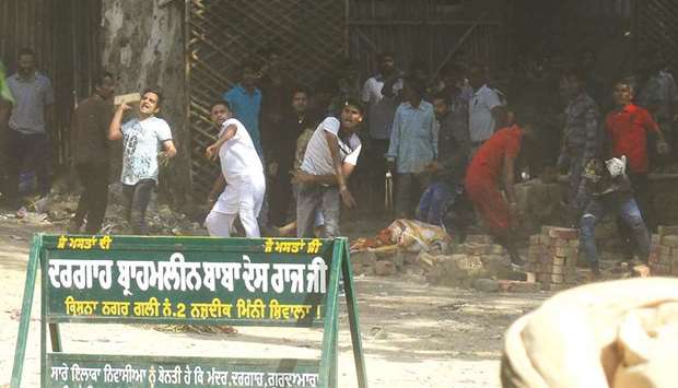 Protesters throw stones towards Punjab Police personnel who were clearing the railway track in Amritsar yesterday.