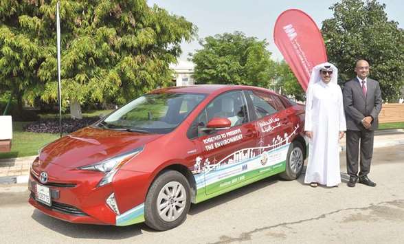 Public Parks Department director Mohamed al-Khouri and AABu2019s acting CEO/COO R K Murugan after the signing of the MoU pose with Toyota Prius Hybrid. PICTURE:  Noushad Thekkayil