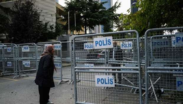 A woman stands next to police barriers, in front of the Saudi consulate in Istanbul