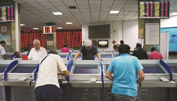 Investors look at computer screens showing stock information at a brokerage house in Shanghai. A measure of realised 10-day swings for the Shanghai Composite Index has jumped to about 45%, the highest of 47 benchmarks tracked by Bloomberg in emerging and developed markets.