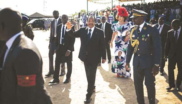 President Paul Biya, accompanied by his wife Chantal Biya, greets the military forces upon arrival at Maroua airport during an election campaign visit to the Far North Region of Cameroon last month.