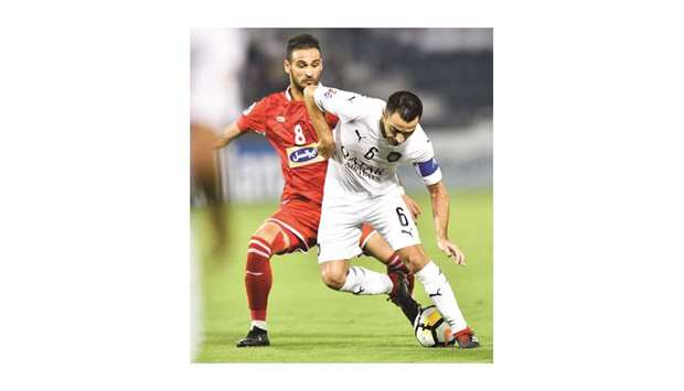 Al Sadd captain Xavi (right) vies for the ball with Persepolisu2019 Ahmad Nourollahi during the first leg of the AFC Champions League semi-final at Jassim Bin Hamad Stadium yesterday. PICTURES: Noushad Thekkayil