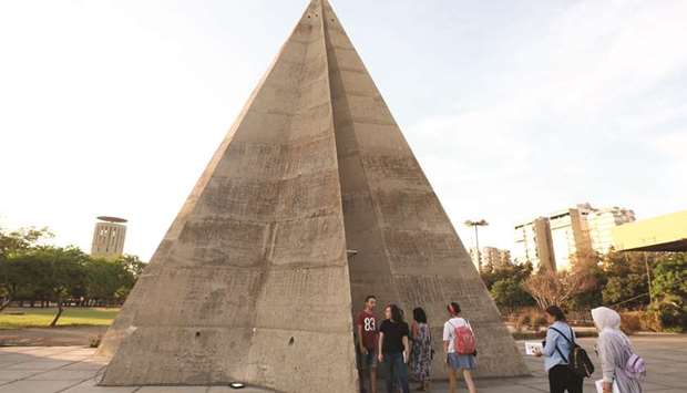 Visitors gather by the stone pyramid during an exhibition at the grounds of the Tripoli International Fair, close to the seafront of the northern  Lebanese port city.
