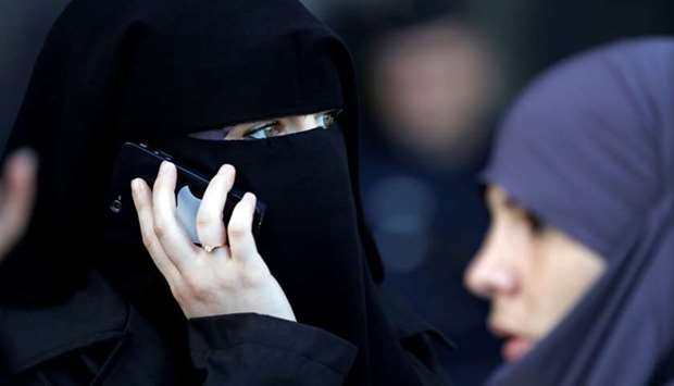 A women, wearing a niqab, gives a phone call outside the courts in Meaux, east of Paris.  September 22, 2011 file picture.