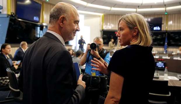 European Economic Commissioner Moscovici talks with EU Foreign Policy Chief Mogherini as they arrive to take part in a weekly college meeting of the European Commission in Strasbourg