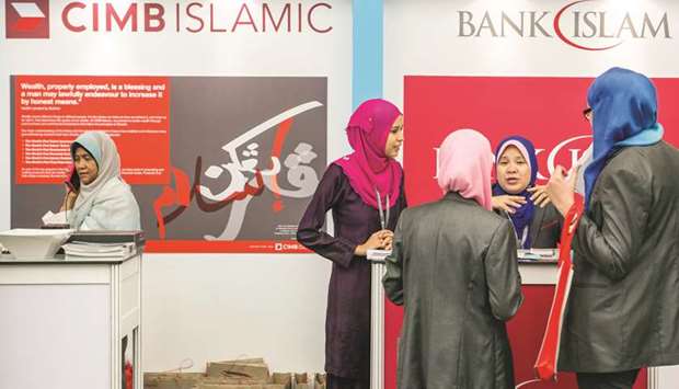 Women stand at the CIMB Islamic Banking Bhd and the Bank Islam Malaysia Bhd booths at the Global Islamic Finance Forum in Kuala Lumpur on  September 3, 2014. Standardisation is becoming more necessary because Islamic finance is now systemically important in over a dozen countries, including Malaysia and Qatar, while countries like Morocco and Kenya have opened up to the sector in recent years.
