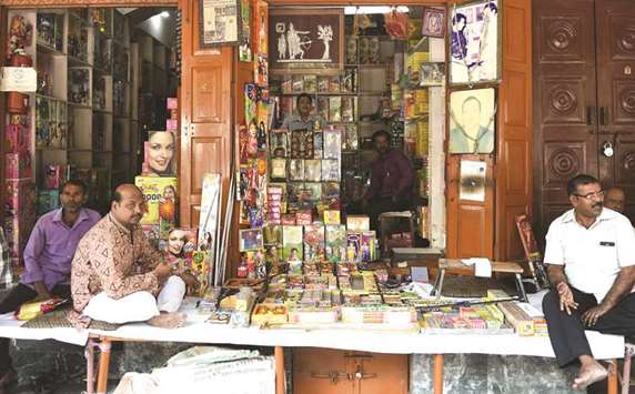 Shopkeepers wait for customers on their firecracker shop in New Delhi yesterday.