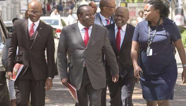 South African Minister of Finance Tito Mboweni (centre) walks with members of the Finance Ministry up Government Avenue as he arrives to deliver his budget speech in the South African Parliament in Cape Town.