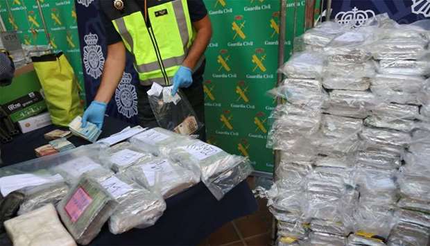 Police display a portion of the six tonnes of cocaine, money and other material seized at an industrial estate at the police headquarters in Malaga