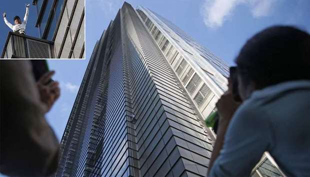 People look up as French urban climber Alain Robert, also known as ,Spider-Man,, climbs Heron Tower