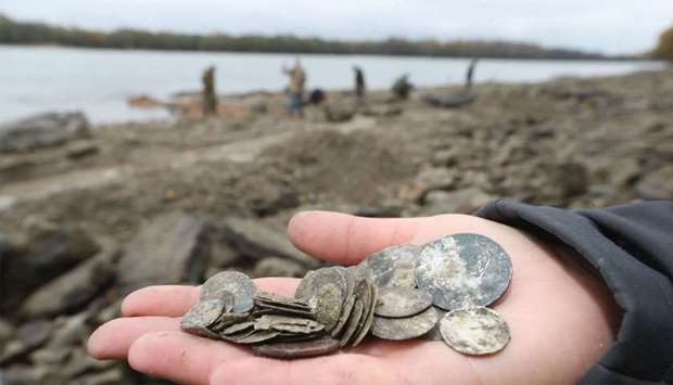 Hungarian archaeologists inspect the site where they found coins from the 16th-17th centuries and special weapons on the banks of the Danube river