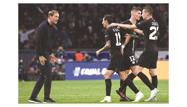 Paris Saint-Germain coach Thomas Tuchel (left) and teammates congratulate midfielder Angel Di Maria (second from left) after he scored a goal during the UEFA Champions League Group C match against Napoli at the Parc des Princes stadium, in Paris, on Wednesday. (AFP)