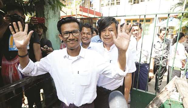 Kyaw Zaw Linn, the editor-in-charge, and two other reporters from Eleven Media walk out of Tamwe court in Yangon yesterday.