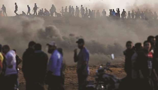 Palestinians gather at the Israel-Gaza border fence during a protest calling for lifting the blockade on Gaza, yesterday.