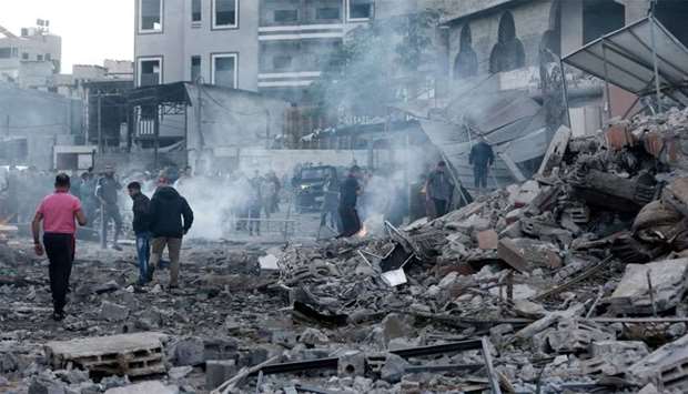 People inspect the rubble of a building following an Israeli air strike on Gaza City 