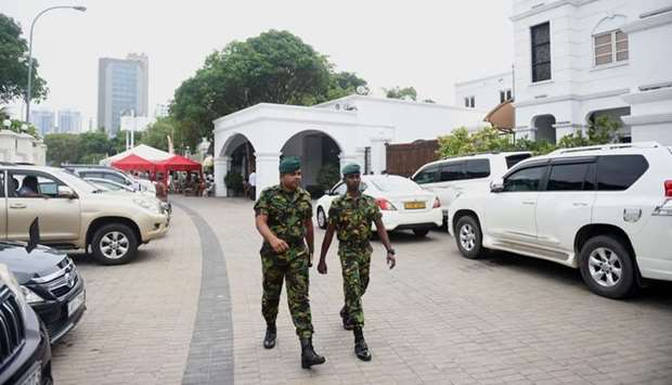 Sri Lankan soldiers walk outside the prime minister's official residence in Colombo.
