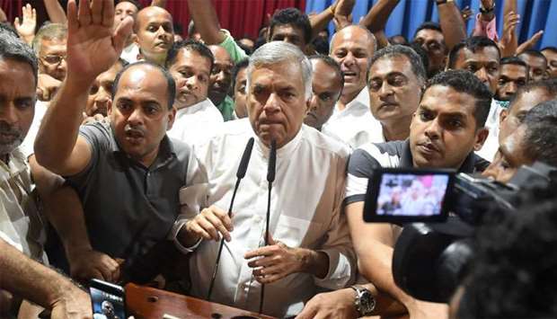 Sri Lanka's ousted prime minister Ranil Wickremesinghe (C) speaks to his supporters at the Prime Minister official residence in Colombo