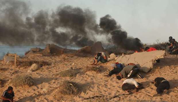 Palestinian protesters burn tyres during a demonstration on the beach near the maritime border with Israel, in Beit Lahia in the northern Gaza Strip.