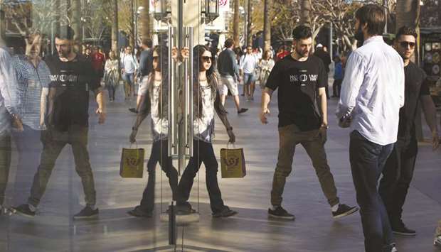 Shoppers are reflected in the window of a store at the Third Street Promenade in Santa Monica, California (file). US consumer spending rose for a seventh straight month in September, but income recorded its smallest gain in more than a year on  moderate wage growth, suggesting the current pace of spending was unlikely to be sustained.