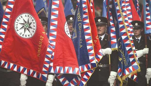 Police officers with flags march during the military parade in Prague.