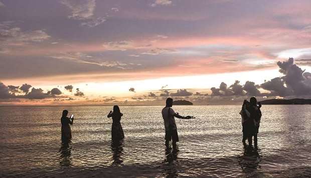 PERFECT SHOT: Instagrammers in a photo trying to snap a perfect photograph at The Tanjung Aru beach in Malaysia.