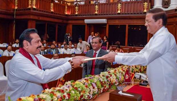 Sri Lanka's newly appointed PM Mahinda Rajapaksa is sworn in as the Minister of Finance and Economic Affairs before President Maithripala Sirisena in Colombo